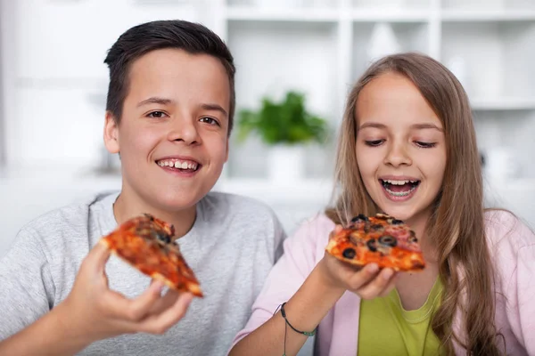 快乐的青少年吃比萨饼与广泛的笑容 — 图库照片