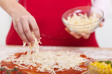 Pizzaya el serpin rendelenmiş peynir