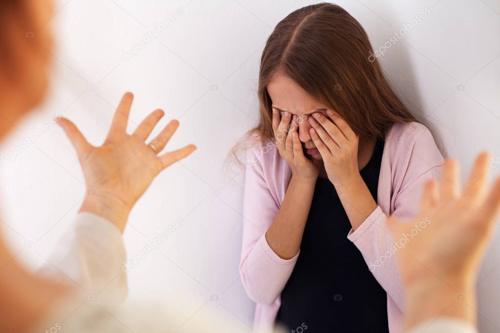 Mother confront young teenager daughter - girl stand by the wall