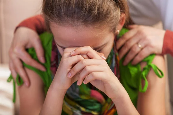 Trauriges Teenager-Mädchen stützt verzweifelt den Kopf - Frauenhände halten — Stockfoto