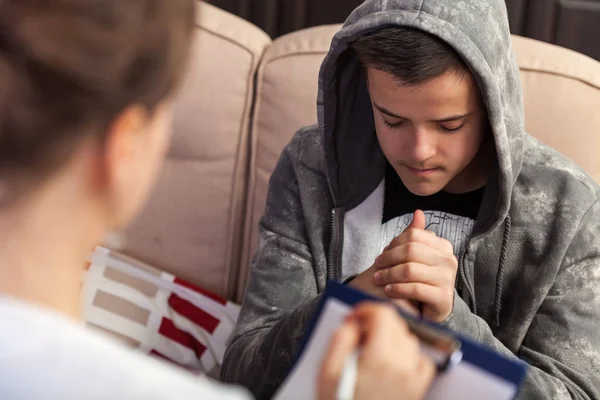 Young boy in trouble sitting on sofa attending a counseling sess — Stock Photo, Image