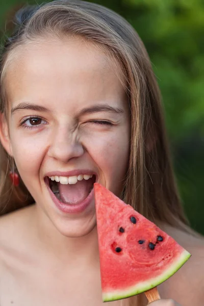 Giovane ragazza si diverte con una fetta sana di anguria — Foto Stock