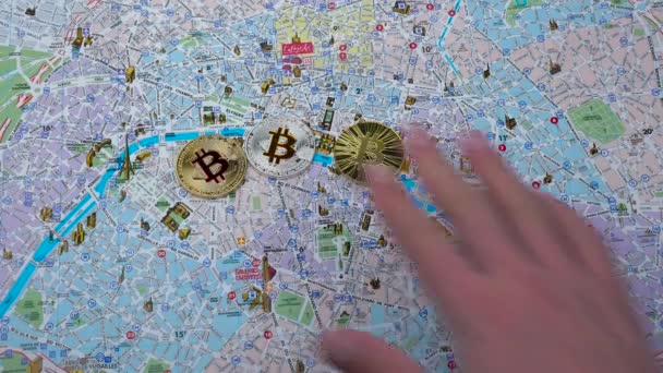 Three bitcoin cryptocurrency coins on the map — Stock Video