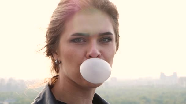 Vrouw is een grote zeepbel blazen met haar kauwgom op straat — Stockvideo