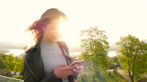 Bella giovane donna alla ricerca di qualcosa in telefono e sorridente — Video Stock