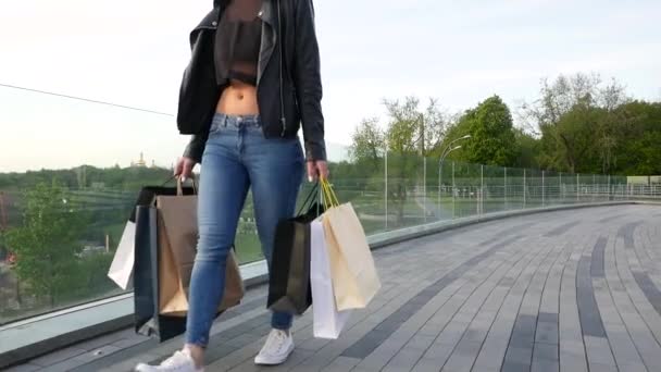 Flicka med shoppingkassar promenad gatan. — Stockvideo