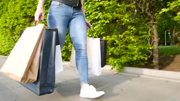 Jonge dame lopen de straat met shopping tassen — Stockvideo