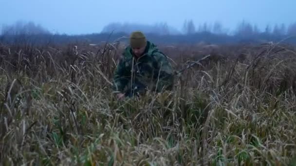 Стрілець з гвинтівкою йде на болоті — стокове відео