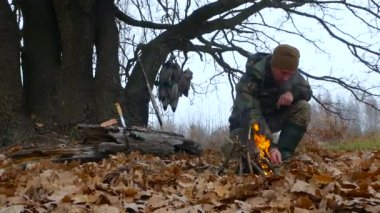 Avcı ormanda bir yangın dinlenme teker teker yapar.