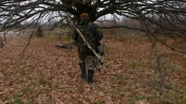 Chasseur avec fusil dans la forêt. Temps de repos sous le grand arbre — Video