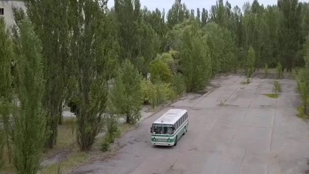 Cidade morta Chernobyl na Ucrânia. Autocarro turístico parado perto das árvores — Vídeo de Stock
