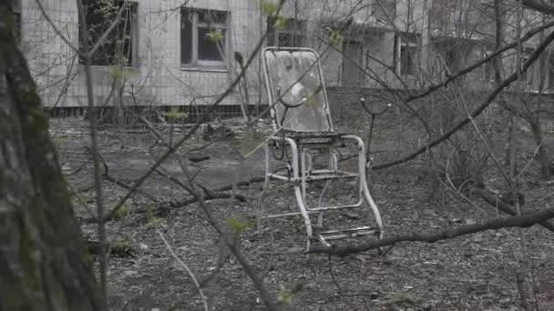 Oude genicologische stoel buiten de hispital in Tsjernobyl-stad — Stockvideo