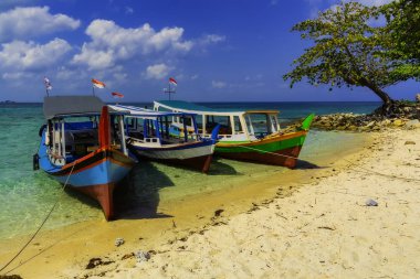 View of the beach with three boats on the island of Kepayang / Belitung /