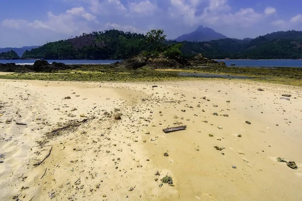 View from the beach in Teluk Kiluan Coconut Island to the surrounding countryside with mountains in the background