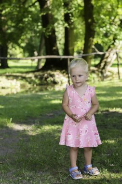 Yaz parkta tek başına ayakta küçük çocuk