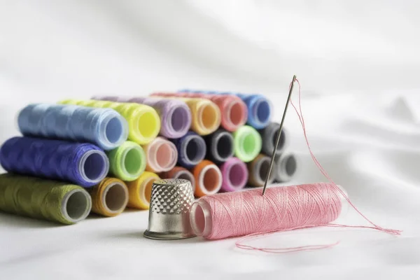 Needle,thimble and colorful spools of thread — Stock Photo, Image