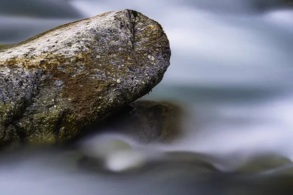 Grande pierre dans un ruisseau coulant de montagne — Photo