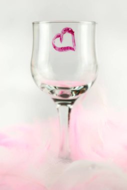 Beyaz arka planda kırmızı kalbi olan ayakta duran cam.