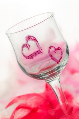 Beyaz arka planda iki kırmızı kalpli ayakta duran cam.