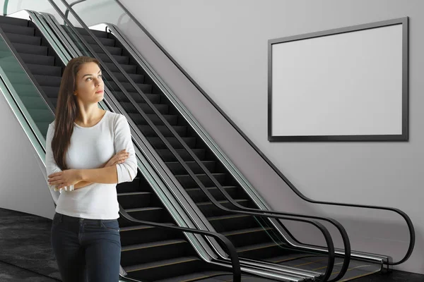 美丽的女人站在地铁与自动扶梯和空的广告牌 广告和商业概念 — 图库照片