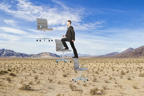 実業家登山の抽象的な砂漠の風景の背景に椅子をフローティングします 成功と夏のコンセプト — ストック写真