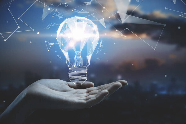 business idea concept with hand holding 3d geometric light bulb at abstract city background