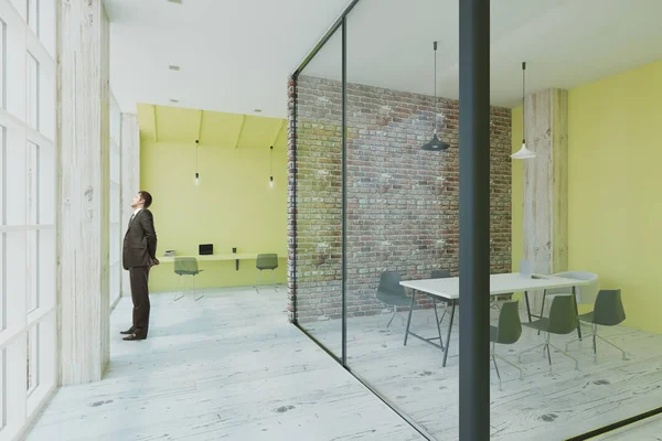 modern ofis withlime renk duvar ve konferans salonunda cam ve tuğla duvarlı pencere bakarak işadamı. 