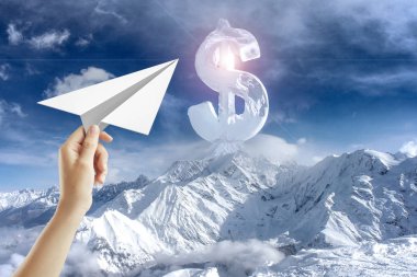 Kağıt Uçak dağ, gökyüzü ve soyut dolar işareti arka planda tutan el. Özgürlük ve Özgürlük kavramı 