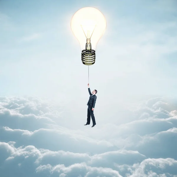 商人乘坐灯泡气球在天空背景云 理念与创新理念 — 图库照片