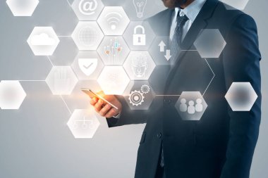 Smartphone ile parlayan iş arayüzey gri arka plan üzerinde tutan işadamı el. AI ve blockchain kavramı. Çift Pozlama 