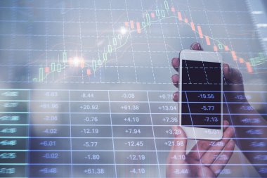 Cep telefonu ve borsa çizelgeleri kullanarak işadamı çift pozlama. Finansal kavram.