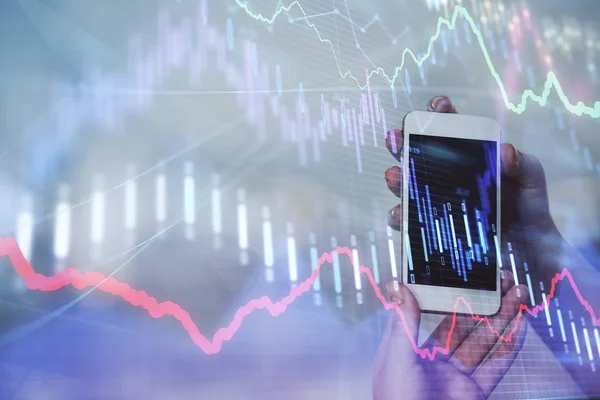 Double exposure of businessman using cell phone and stock market charts. Financial concept.
