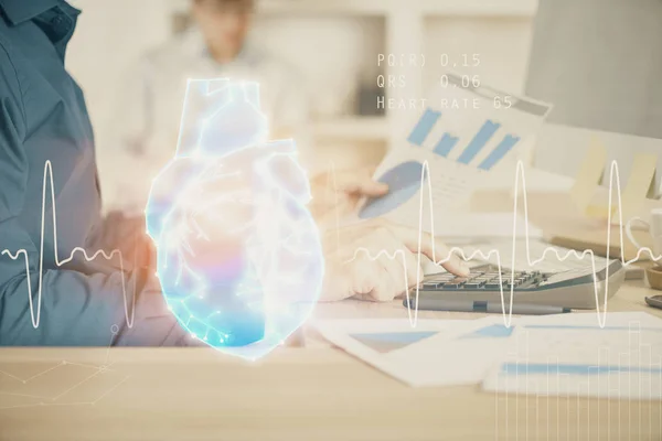 Herzzeichnung mit einem Mann, der im Hintergrund am Computer arbeitet. Medizinisches Konzept. Doppelbelastung. — Stockfoto