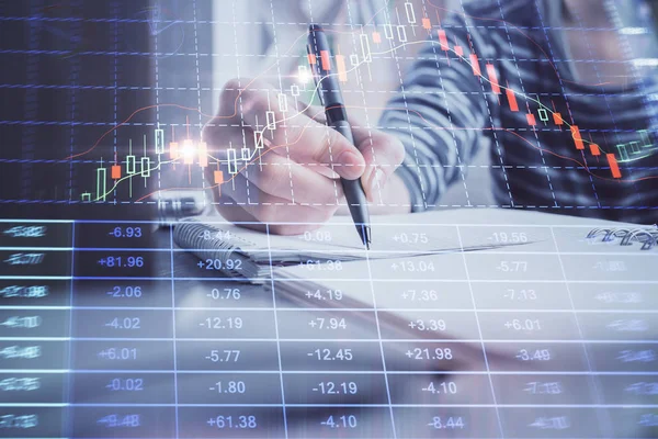 Financial forex graph drawn over hands taking notes background. Concept of research. Double exposure