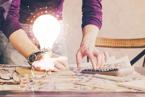 Vista del icono del concepto de la idea de la lámpara de bombilla en una interfaz futurista con el fondo de la mano del hombre de escritura. Doble exposición. —  Fotos de Stock