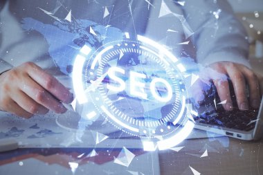 Arka planda bilgisayar üzerinde çalışan bir adamla birlikte çok sayıda simgeye maruz kalma. Arama motoru optimizasyonu kavramı.