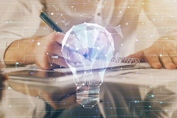 View of Bulb lamp idea concept icon on a futuristic interface with writing man's hand background. Double exposure. — Stock Photo, Image