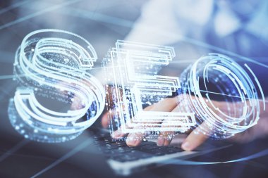 Arka planda bilgisayar üzerinde çalışan bir adamla birlikte çok sayıda simgeye maruz kalma. Arama motoru optimizasyonu kavramı.