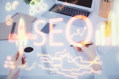 Kadın elinin SEO simgesiyle notlar alırken çoklu pozlanması. Arama motoru optimizasyonu kavramı