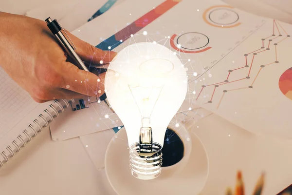 男性の手の背景を書くと未来的なインターフェイス上の電球のランプのアイデアのアイコンのビュー。二重露光. — ストック写真