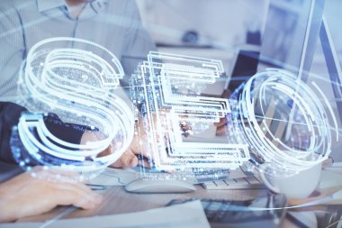 Arka planda bilgisayar üzerinde çalışan bir adamla birlikte çok sayıda simgeye maruz kalma. Arama motoru optimizasyonu kavramı.