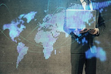 Arka planda dizüstü bilgisayar üzerinde çalışan işadamı çift pozlama. Önde uluslararası iş hologramı. Başarı kavramı.