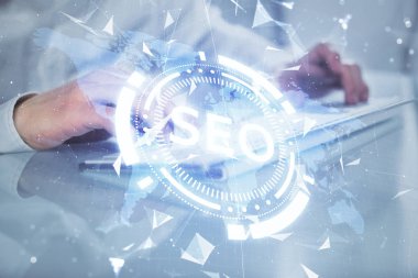 Arka planda bilgisayar üzerinde çalışan bir adamla birlikte çok sayıda simgeye maruz kalma. Arama motoru optimizasyonu kavramı.