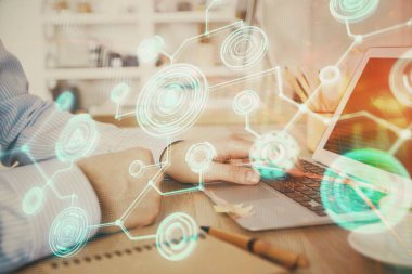 Sosyal ağ temalı hologramda iş adamı arka planda bilgisayar üzerinde çalışıyor. Dünya çapında ağ kavramı. Çoklu pozlama.