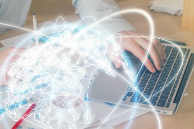 Arka planda dizüstü bilgisayar üzerinde çalışan işadamı çift pozlama. Önde uluslararası iş hologramı. Başarı kavramı.