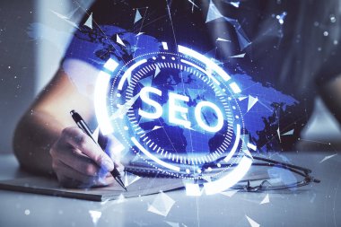 SEO simgesiyle notlar alan bir kadının ellerine iki kez maruz kalmak. Arama motoru optimizasyonu kavramı