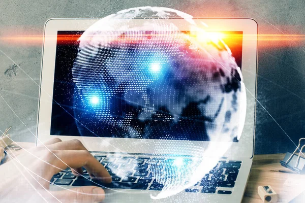 Dubbele blootstelling van zakenman die op de achtergrond aan laptop werkt. International Business hologram vooraan. Concept van succes. — Stockfoto