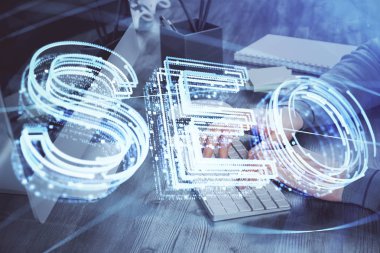 Arka planda bilgisayar üzerinde çalışan bir adamla birlikte çok sayıda simgeye maruz kalma. Arama motoru optimizasyonu kavramı.