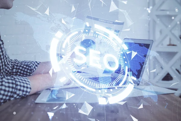 Arka planda bilgisayarla çalışan bir adamla iki kez simgeye maruz kalıyoruz. Arama motoru optimizasyonu kavramı.