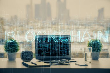 Engelleme zinciri ve kripto ekonomi temalı hologram ve bilgisayar geçmişi olan bir masa. Bitcoin kripto para kavramı.